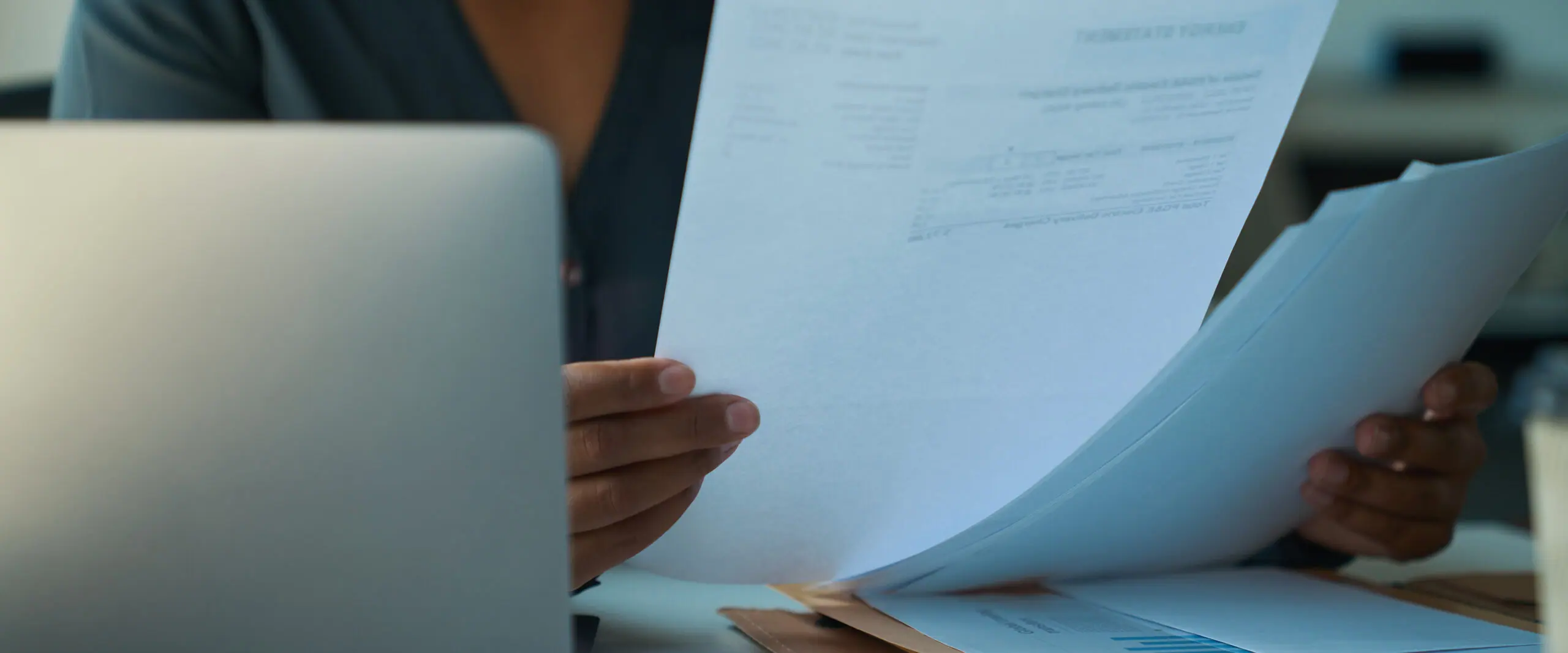 Business owner reviewing printed documents at a desk