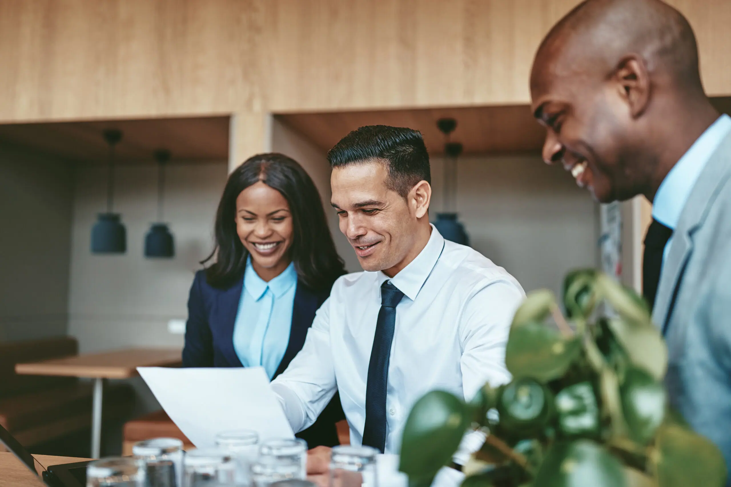 Smiling advisory team reviewing documents together in an office
