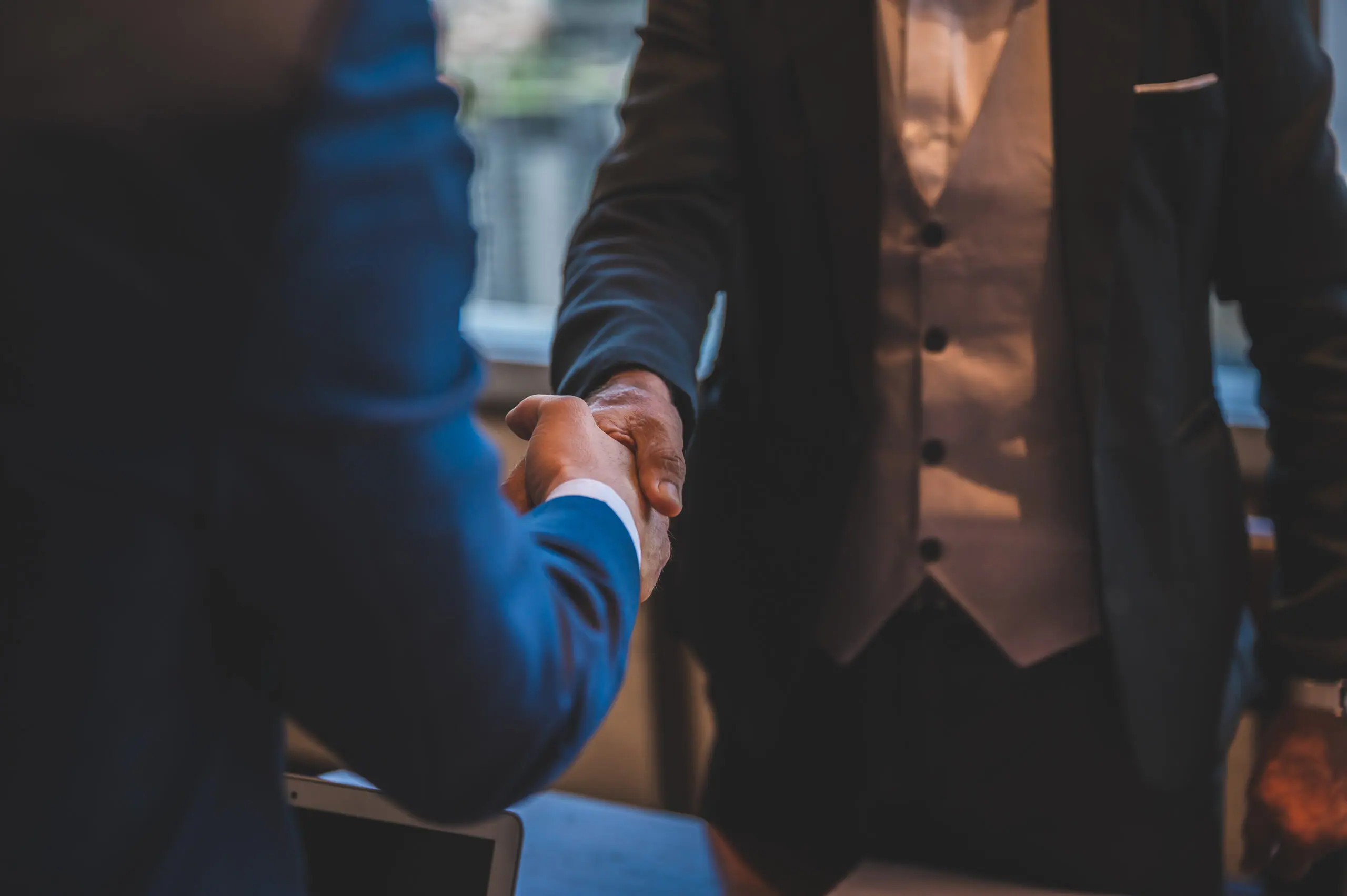 Two businesspeople in suits shaking hands