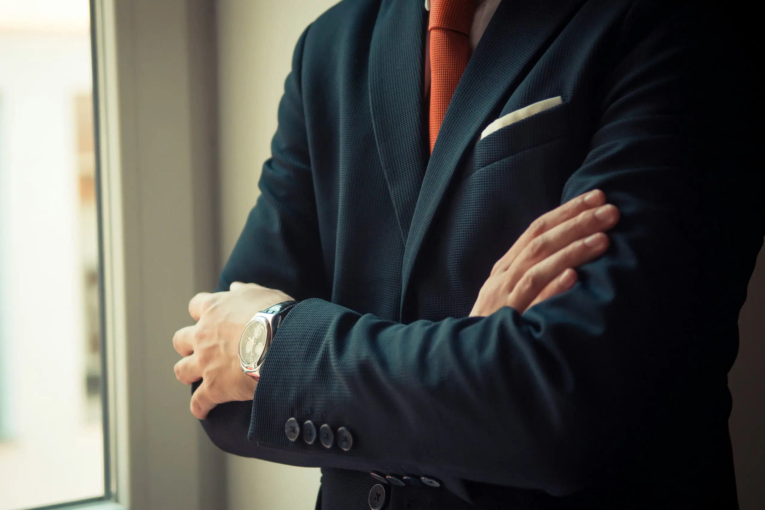 Executive in a dark suit with arms crossed